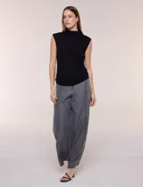 Musculosa negra de modal, con cuello alto, sin mangas y frunces drapeados en los laterales de la cintura.
