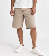Bermuda baggy de jean color beige con efecto pigmentado, de corte holgado y diseño clásico de cinco bolsillos.