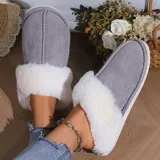 Pantufla cerrada de gamuza gris con interior y borde de peluche blanco, suela de goma antideslizante.