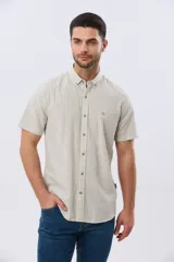Camisa de manga corta confeccionada en mezcla de lino y algodón, con diseño de rayas verticales en tonos beige y blanco, cuello abotonado y cierre frontal con botones.