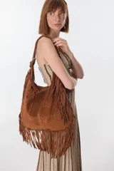 Bolso marrón de gamuza con flecos, con correa de hombro y herrajes metálicos.