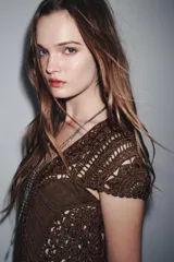 Vestido largo color marrón con detalle de crochet en el corpiño, escote redondo y manga corta. Cierre en la espalda con lazadas.