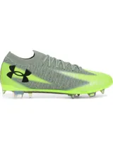 Championes de fútbol Under Armour Shadow Elite 3 FG, diseñados para velocidad y agilidad. Presentan una parte superior de tejido IntelliKnit gris con detalles en verde neón, logotipo de la marca en negro y suela exterior de fibra de carbono para máxima aceleración en superficies naturales.