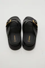 Sandalias planas de eco cuero color bordó, con tiras cruzadas y hebilla metálica dorada.