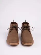 Botas tipo chukka color marrón, con cordones al tono, costuras reforzadas y suela de goma en color caramelo.
