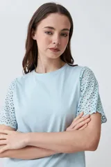 Remera fucsia de manga corta con detalle de broderie en las mangas.