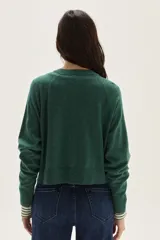 Cardigan de tejido de punto en color azul, con cuello redondo, cierre frontal con botones al tono y mangas largas con puños acanalados. Presenta un diseño clásico y versátil.