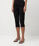 Pantalón capri negro de malla crepé, con pliegues delanteros y sin estampado.