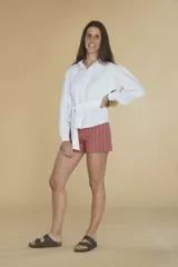 Camisa blanca de lino con mangas largas abullonadas y lazo en la cintura.