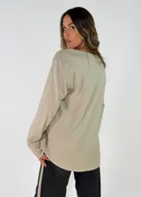 Blusa de manga larga en color blanco, con cuello redondo y detalle de alforzas verticales en el frente. Presenta un corte holgado y fluido.