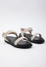 Sandalia baja negra con doble tira en el empeine tejida en beige y negro, tira de agarre en el tobillo con hebilla y plataforma de 3 cm de alto.