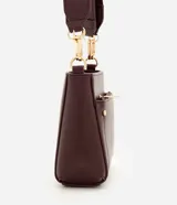 Cartera bandolera de poliuretano color marrón oscuro, con estructura firme y tamaño mediano. Cuenta con un bolsillo frontal con cierre, herrajes metálicos dorados, cierre principal y correa ajustable y desmontable.