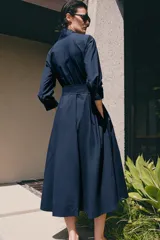 Vestido midi de algodón con cuello con lazada, manga tres cuartos y falda evasé. Incluye cinturón ajustable del mismo tejido y cierre frontal con botones.