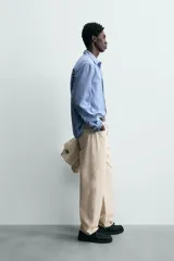 Camisa de hombre de manga larga, color azul, con cuello solapa y bolsillo plastrón en el pecho. Presenta un patrón de cuadros pequeños en tonos de azul y blanco.