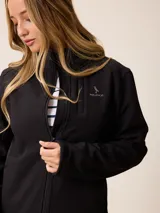 Campera softshell blanca con cierre frontal completo, cuello alto y bolsillos laterales. Presenta un bolsillo vertical con cierre en el pecho y el logo de la marca bordado.