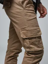 Pantalón cargo color verde militar, de corte slim, con bolsillos laterales con tapeta, bolsillos frontales y traseros.