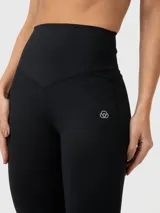 Calza deportiva de tiro alto con diseño acampanado y banda de compresión en la cintura. Presenta un pequeño logo bordado en la cadera izquierda.