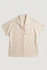 Sobrecamisa roja de lino de manga corta, con cuello solapa, costuras decorativas en contraste y cierre frontal con presillas y botones alargados.
