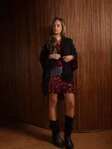 Ruana de tejido de punto en color crudo con destellos de lurex, presenta un diseño holgado con flecos en el ruedo.