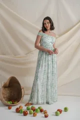 Vestido largo de gasa de seda natural estampada en tonos blanco, verde y amarillo. Diseño drapeado con escote barco y manga caída, falda con movimiento y tajo lateral.