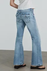 Jeans de tiro bajo con diseño bootcut y acabado flare en el bajo. Cuenta con cinco bolsillos, trabillas para cinturón y cierre frontal con cremallera y botón metálico.