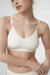 Sostén tipo bralette color beige, de tela acanalada, con breteles ajustables, doble tela y espalda con broche de tres medidas. Sin relleno ni aro.