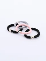 Pack de cuatro coleros para el pelo, de colores negro, gris y rosa, con adorno metálico plateado en forma de moño.