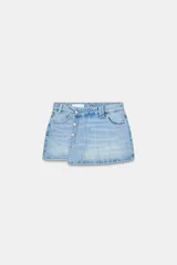 Falda pantalón de denim, tiro alto, color celeste claro lavado. Presenta un cruce frontal con cierre de botones metálicos y cinco bolsillos estilo jean.