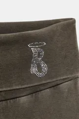 Pantalón de tiro alto con cintura doblada y diseño acampanado, confeccionado en tejido de algodón con efecto lavado. Presenta un detalle de aplicación de brillos en la cintura.