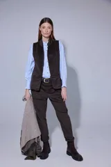 Chaleco de corte sastrero en tela de pana con diseño a cuadros oscuros, cuello mao y cierre frontal con botones.