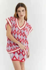 Chaleco tejido de lana con patrón de rombos en tonos lila, rojo y beige, con cuello en V y ribetes en color crema. Diseño oversize.