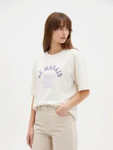 Remera de algodón negra con cuello redondo y mangas cortas, de corte holgado. Presenta estampado frontal en tonos de verde con la inscripción 'New York City Brooklyn' y el logo 'NY' rodeado de laureles.