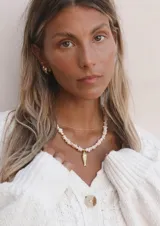 Collar de piedra natural morganita en formato de nuggets rosadas, con dije colgante en forma de pez dorado y detalles en acero dorado.