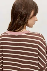 Remera de manga corta con diseño a rayas horizontales azules y blancas, cuello redondo en color tostado y parche bordado en el pecho.