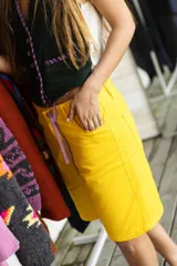 Bermuda de jean de color amarillo, de tiro alto y corte recto.