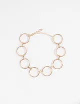 Choker de metal dorado compuesto por una cadena de aros grandes interconectados, con cadena de ajuste y cierre de mosquetón en la parte posterior.