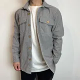 Sobrecamisa de paño con diseño de espiga, cuello clásico, cierre frontal con botones y dos bolsillos frontales con solapa.