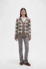 Cardigan de punto con diseño de cuadros, cuello en V y cierre frontal con botones. Presenta un corte holgado y mangas largas.