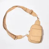 Riñonera porta celular color beige con correa de tela estampada ajustable.