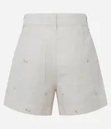 Short de cintura alta confeccionado en tejido de algodón, viscosa y lino. Cuenta con bordado floral, trabillas en la cintura, bolsillos y cierre frontal con botón forrado.