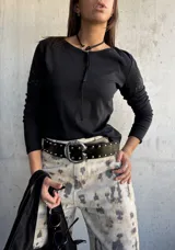 Remera de manga larga color negro, con cuello redondo y detalle de bordado floral sutil en el hombro. Confeccionada en algodón, presenta un corte ajustado y versátil.