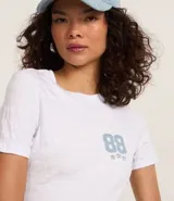 Remera blanca de algodón con cuello redondo, manga corta y estampa lettering college en el frente.