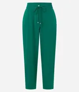 Pantalón de crepé rojo, modelo estilo pijama, de corte fluido, con cintura elástica y lazo de ajuste con terminales metálicas. Cuenta con bolsillos laterales y cierre frontal con cremallera y botón.