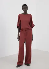 Pantalón palazzo largo de tiro alto, color bordó, con cintura elástica y lazo ajustable.