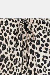 Pantalón de tiro medio con estampado animal print de leopardo, cintura elástica ajustable con cordón y perneras amplias y rectas.