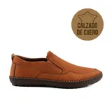 Zapato casual de cuero color marrón, tipo mocasín, sin cordones, con elásticos laterales y suela de goma marrón con costuras visibles.