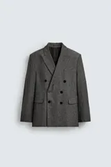Blazer de corte relajado confeccionado en tejido con lana, con diseño de espiga. Presenta cuello con solapas de muesca, cierre frontal de botonadura cruzada, bolsillos de vivo en el pecho y bolsillos de solapa en la cadera.
