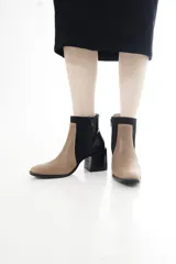 Botas cortas de cuero vacuno en combinación de colores tostado y negro, con diseño bicolor y paneles laterales de gamuza, punta cuadrada y taco bloque ancho.