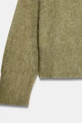 Jersey de punto con textura efecto cepillado, cuello en V y manga larga con terminaciones en rib.