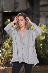 Saco de lanilla gris con textura de espiga, corte oversize, cuello en V, cierre con botones de madera, bolsillos frontales y volados en el ruedo.